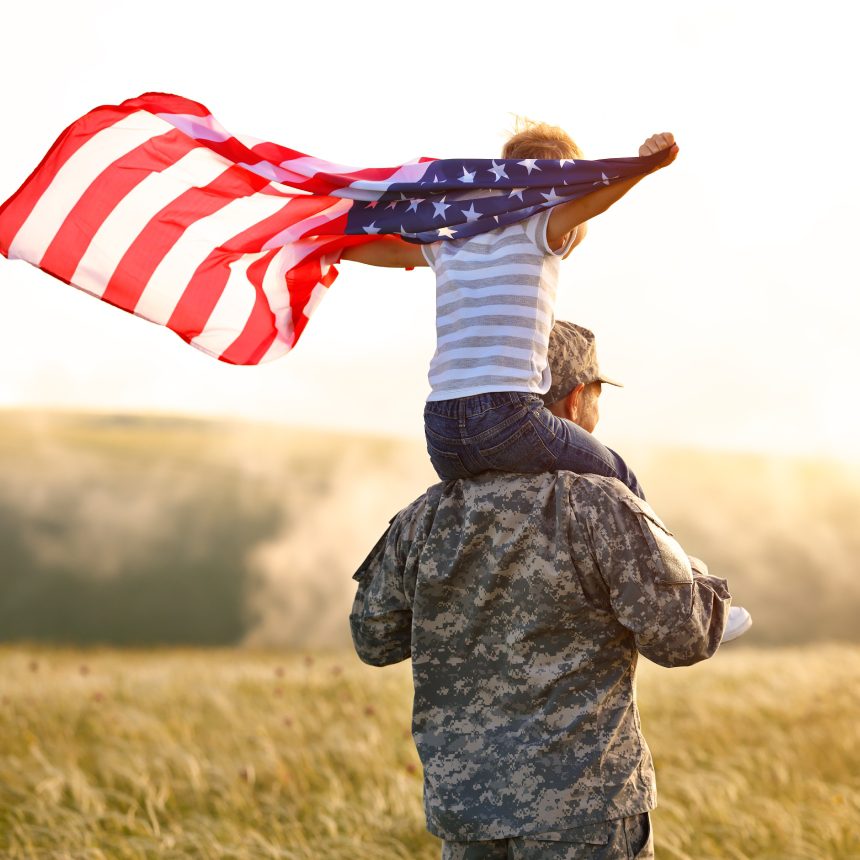 Soldier and child with American flag.